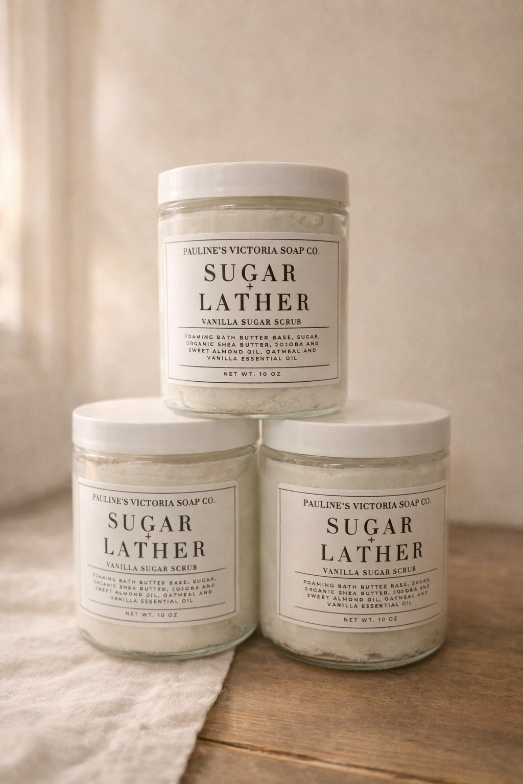 Three jars of Pauline's Victoria Soap Co. Sugar Lather on a wooden surface with a neutral background.