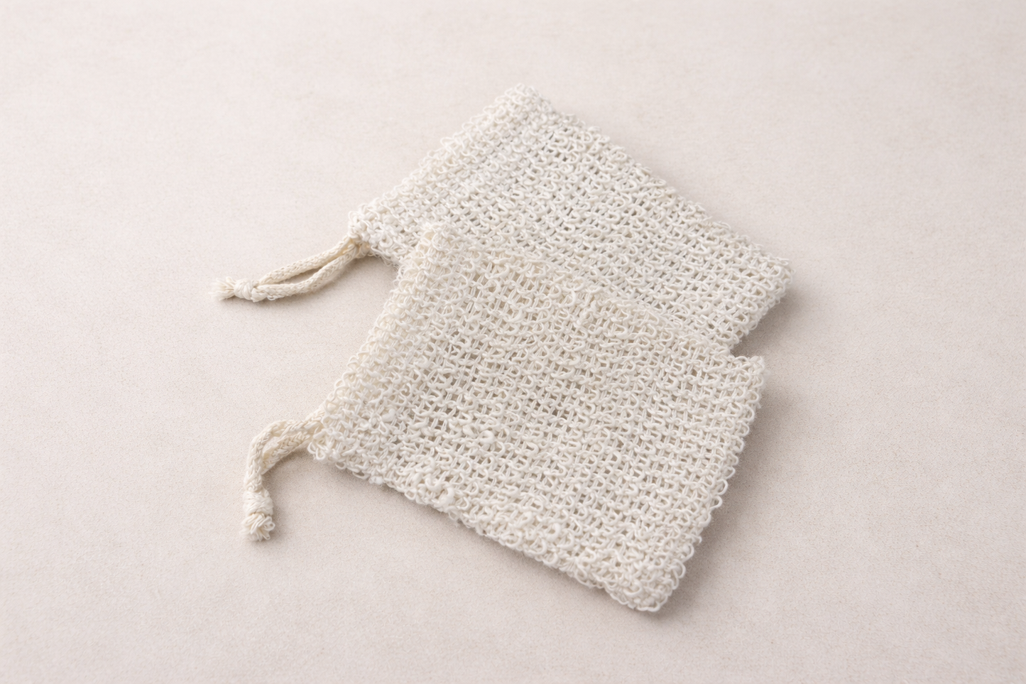 Two sisal soap savers similar to mesh drawstring bag.