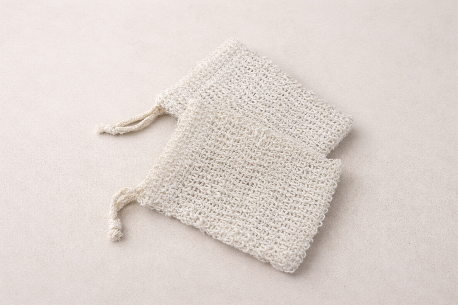 Two sisal soap savers similar to mesh drawstring bag.
