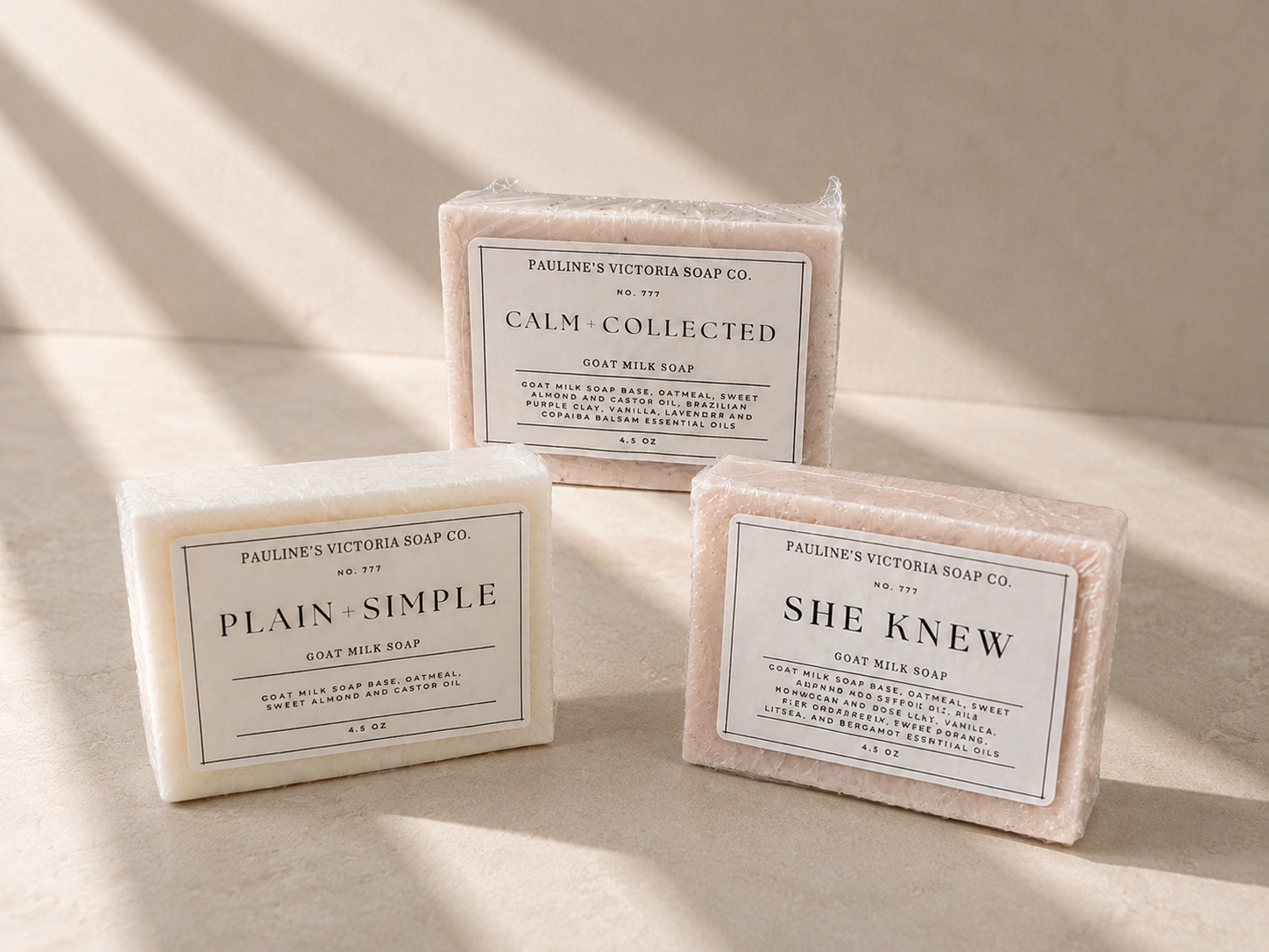 Three bars of soap with labels on a beige surface