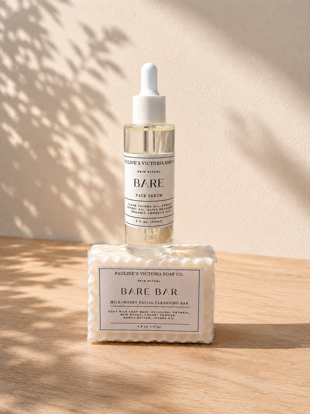 Bare Bar facial cleansing bar and serum bottle on a wooden surface with a neutral background