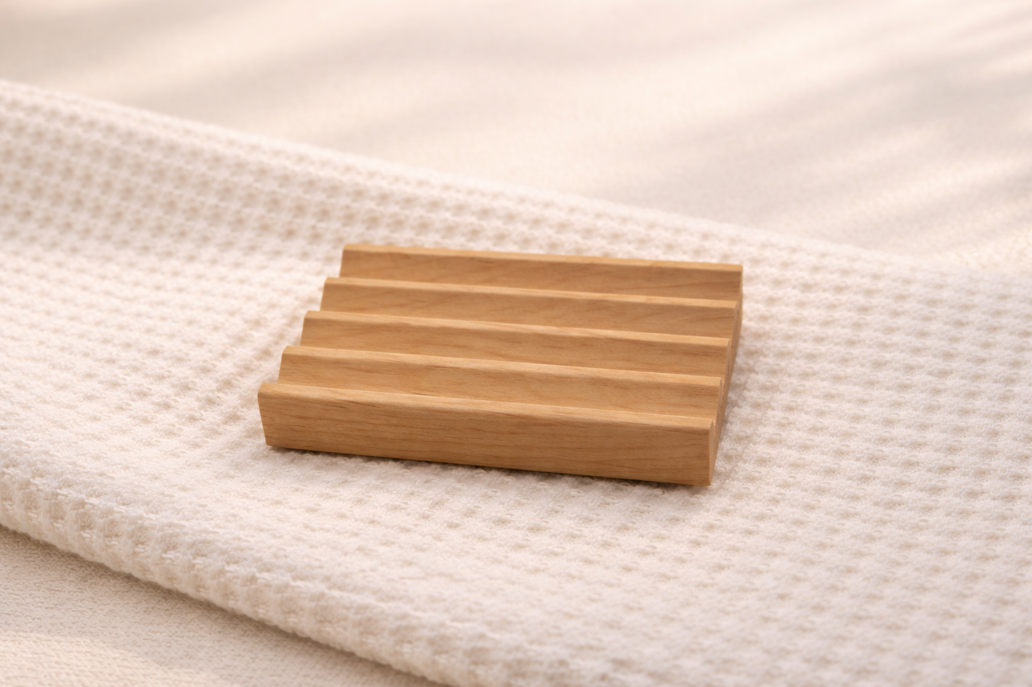 Wooden soap dish on a textured white surface